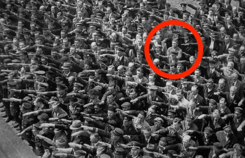 Hombre resistiéndose a saludar a Hitler